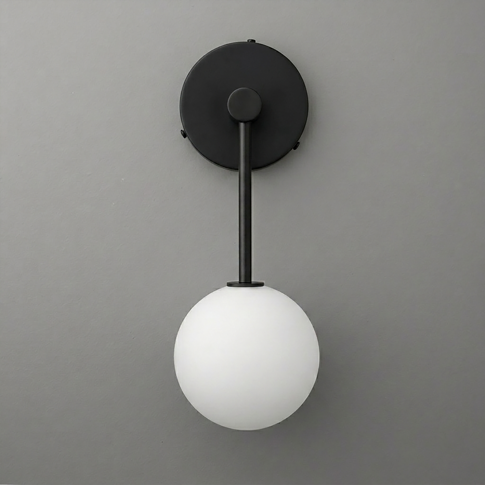 Black metal wall sconce with matte finish and single frosted white glass globe light shade. - Sconce Model No. 5999