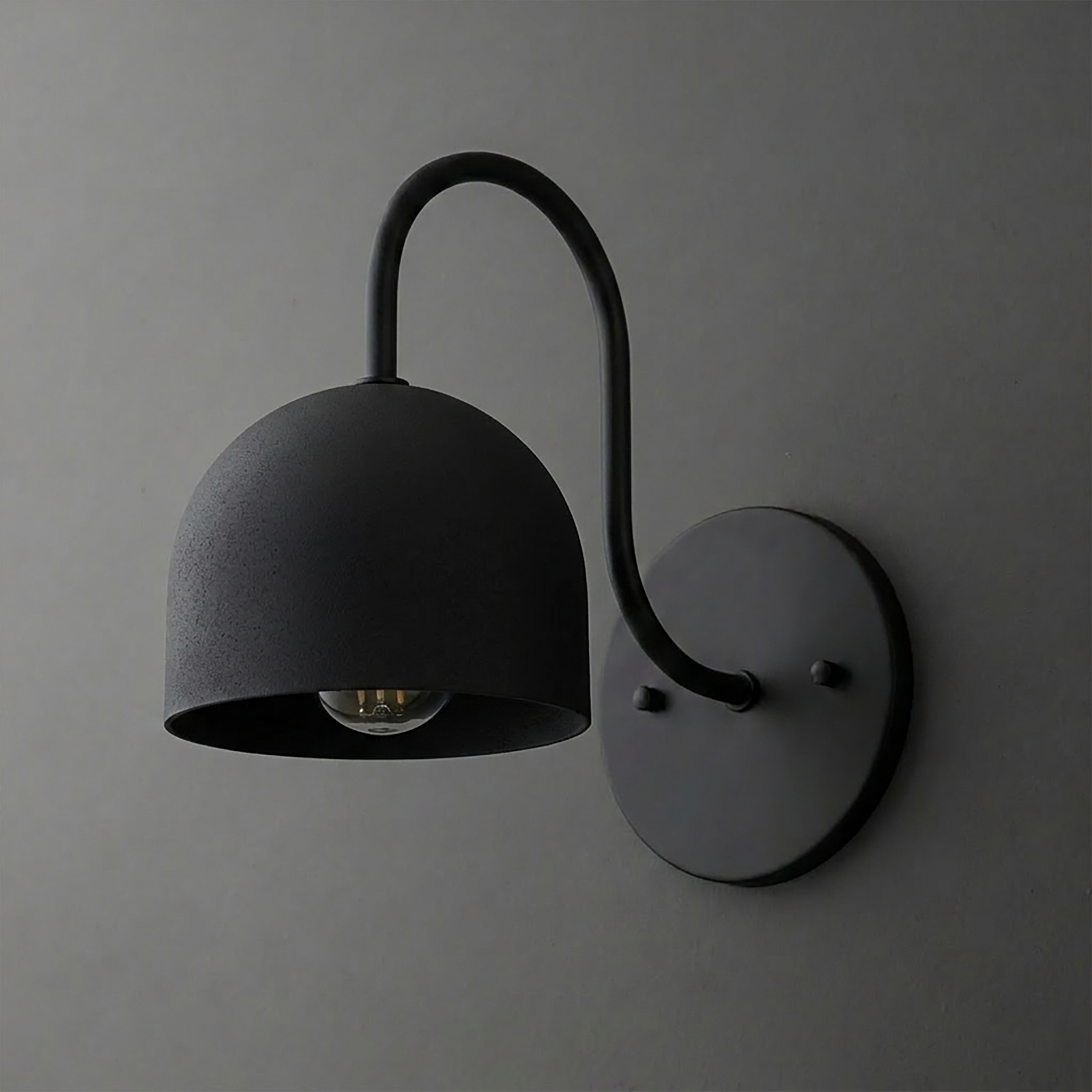 Matte black metal wall sconce with a curved arm and deep dome-shaped shade covering one bulb. - SCONCE MODEL NO. 6308