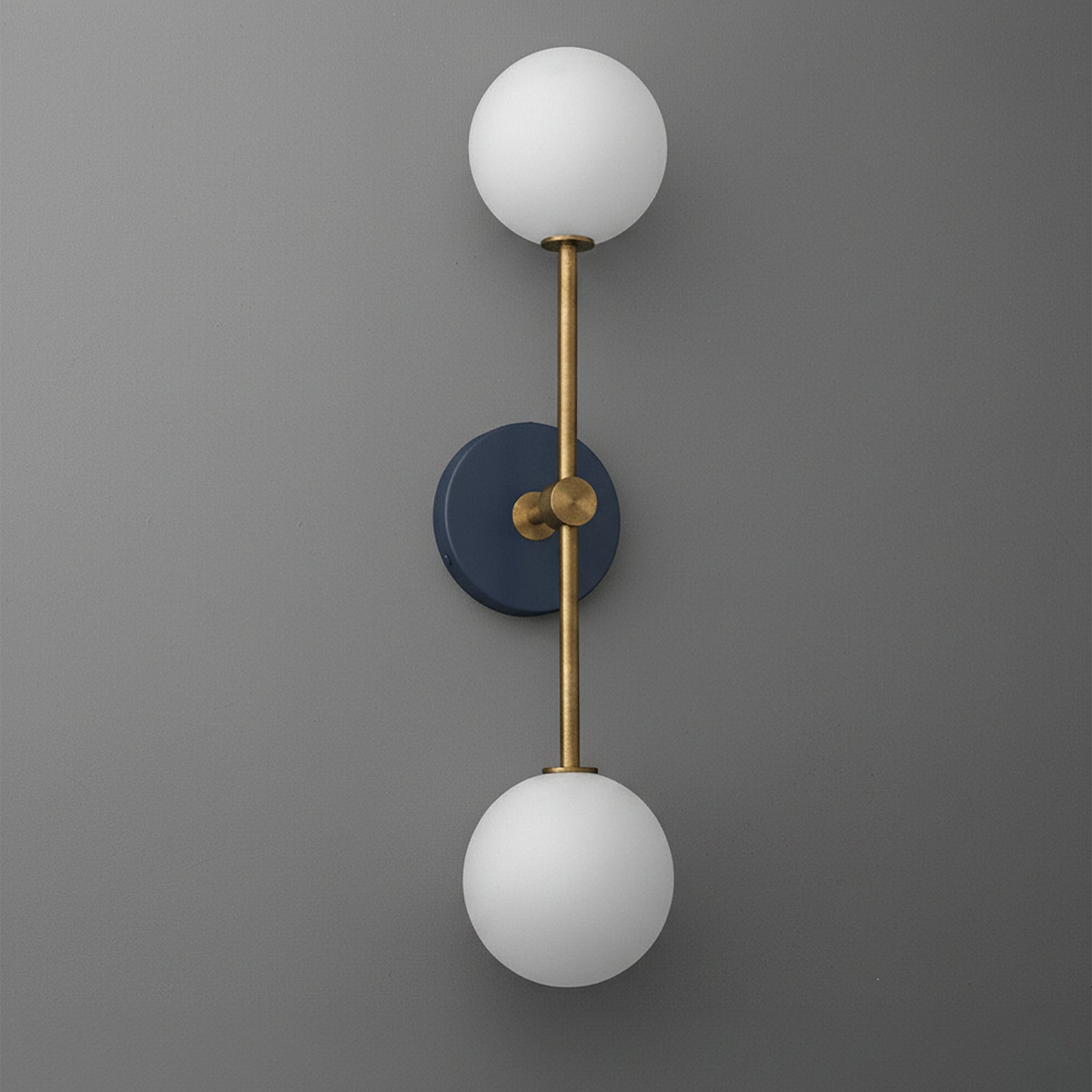 Raw brass and coal blue wall sconce with two white glass globe shades, vertical design. - SCONCE MODEL NO. 9776