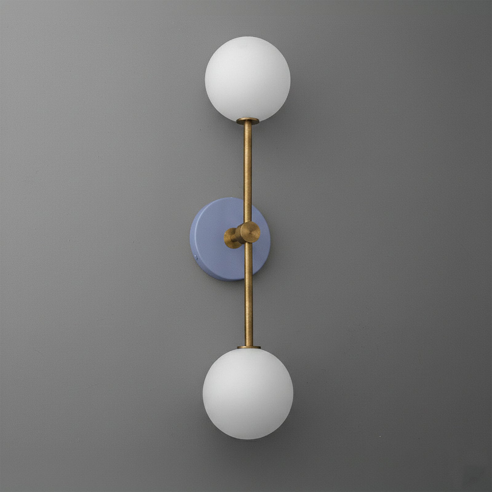 Wall sconce with raw brass finish and periwinkle circular backplate, featuring two white frosted glass globes. - SCONCE MODEL NO. 9776