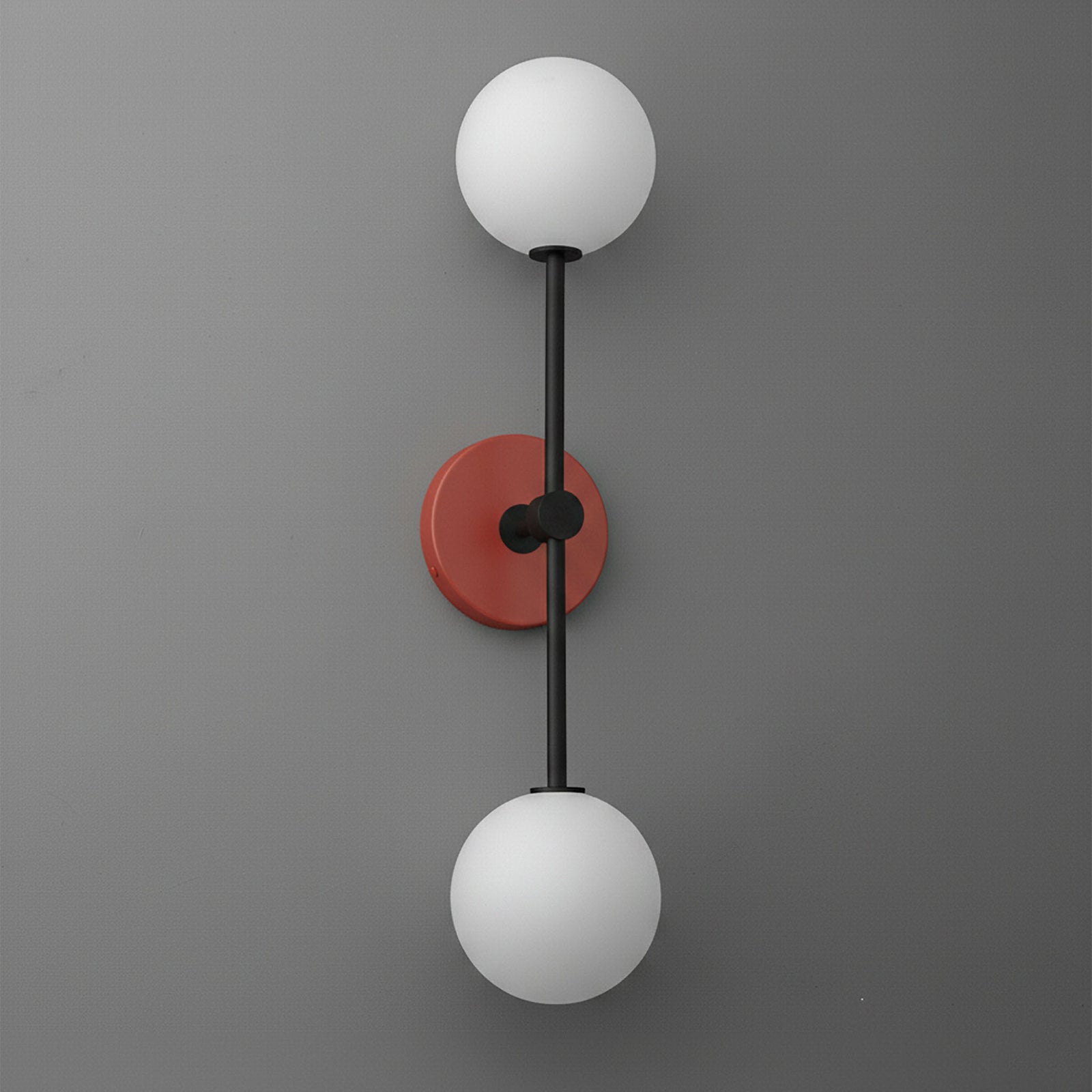 Double globe wall sconce with black metal rod and brick red circular base on gray background. - SCONCE MODEL NO. 9776