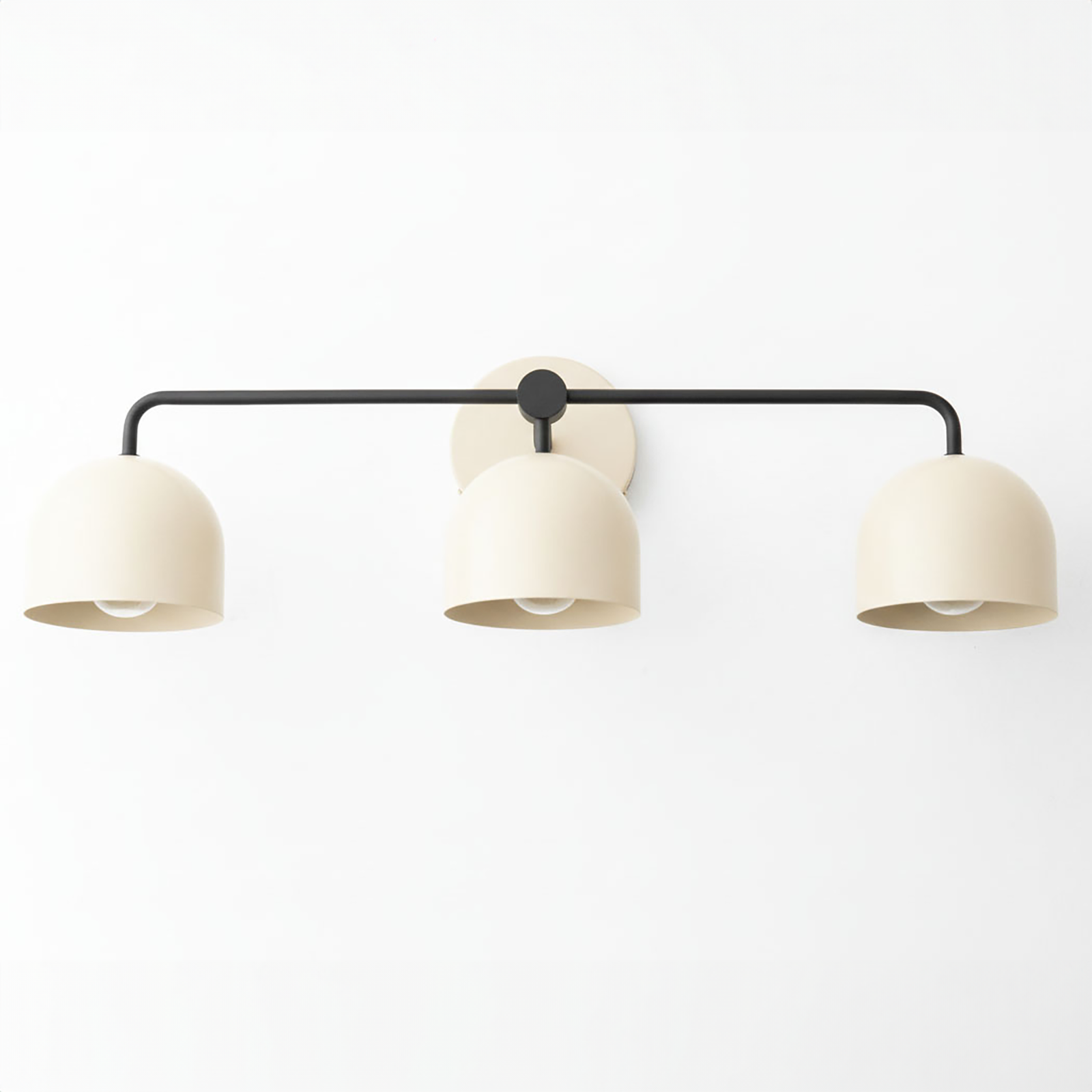 Mid-century modern vanity light with three matte beige dome shades on a black horizontal metal bar and round wall mount. - VANITY LIGHT MODEL NO. 7456