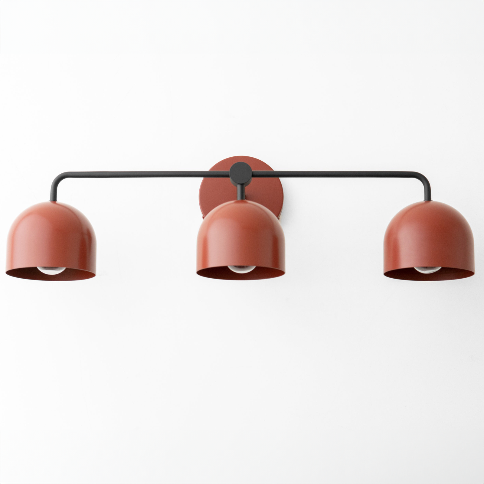 Mid-century modern vanity light with three rust-colored metal dome shades on a black horizontal rod. - VANITY LIGHT MODEL NO. 7456
