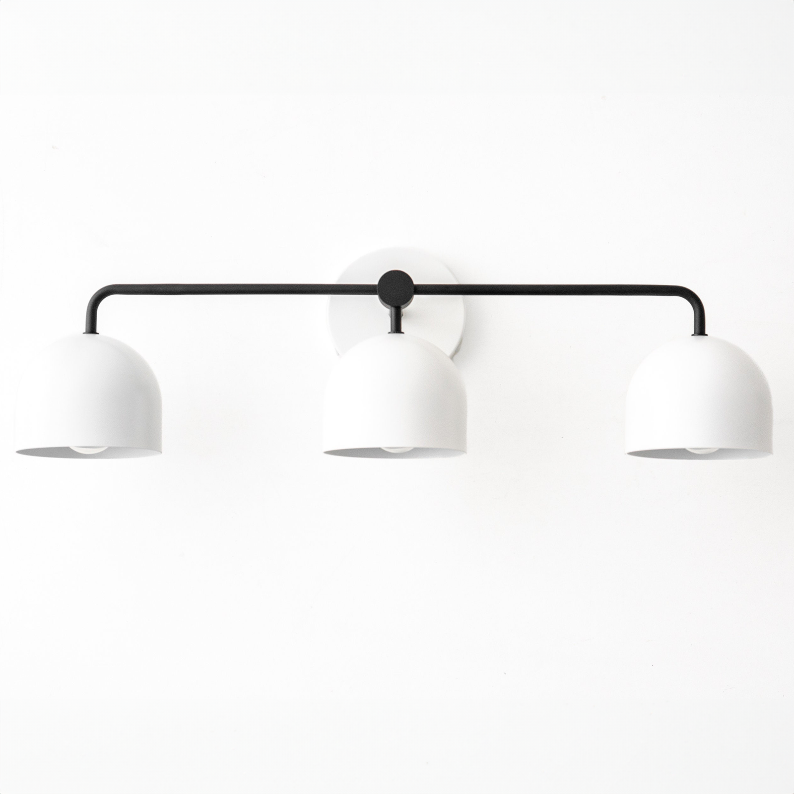 Mid-century modern black vanity light with three white dome-shaped shades and a circular wall mount. - VANITY LIGHT MODEL NO. 7456