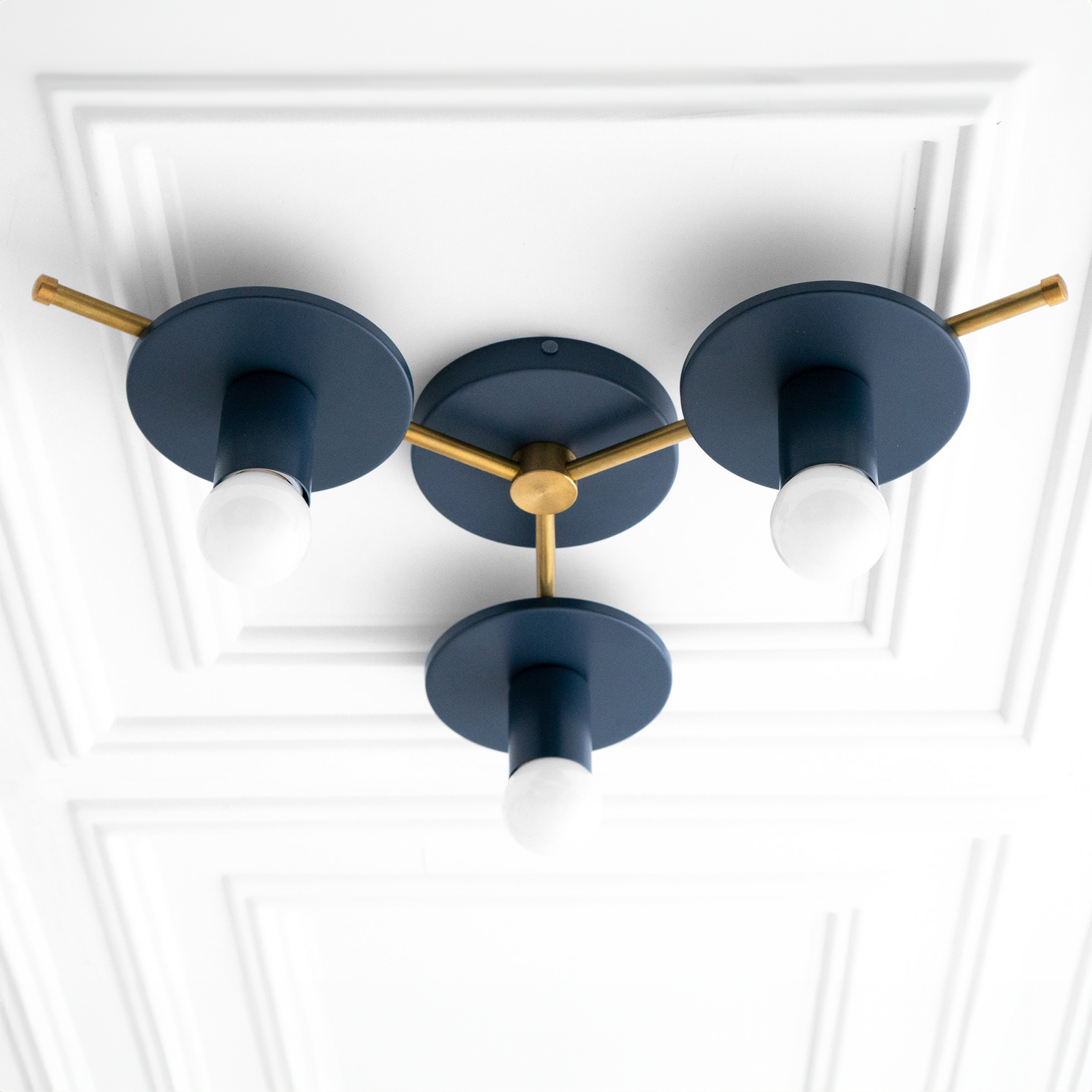 Mid-century modern flush mount chandelier with three exposed bulbs and matte navy blue arms connected by antique brass. - CHANDELIER MODEL NO. 9526