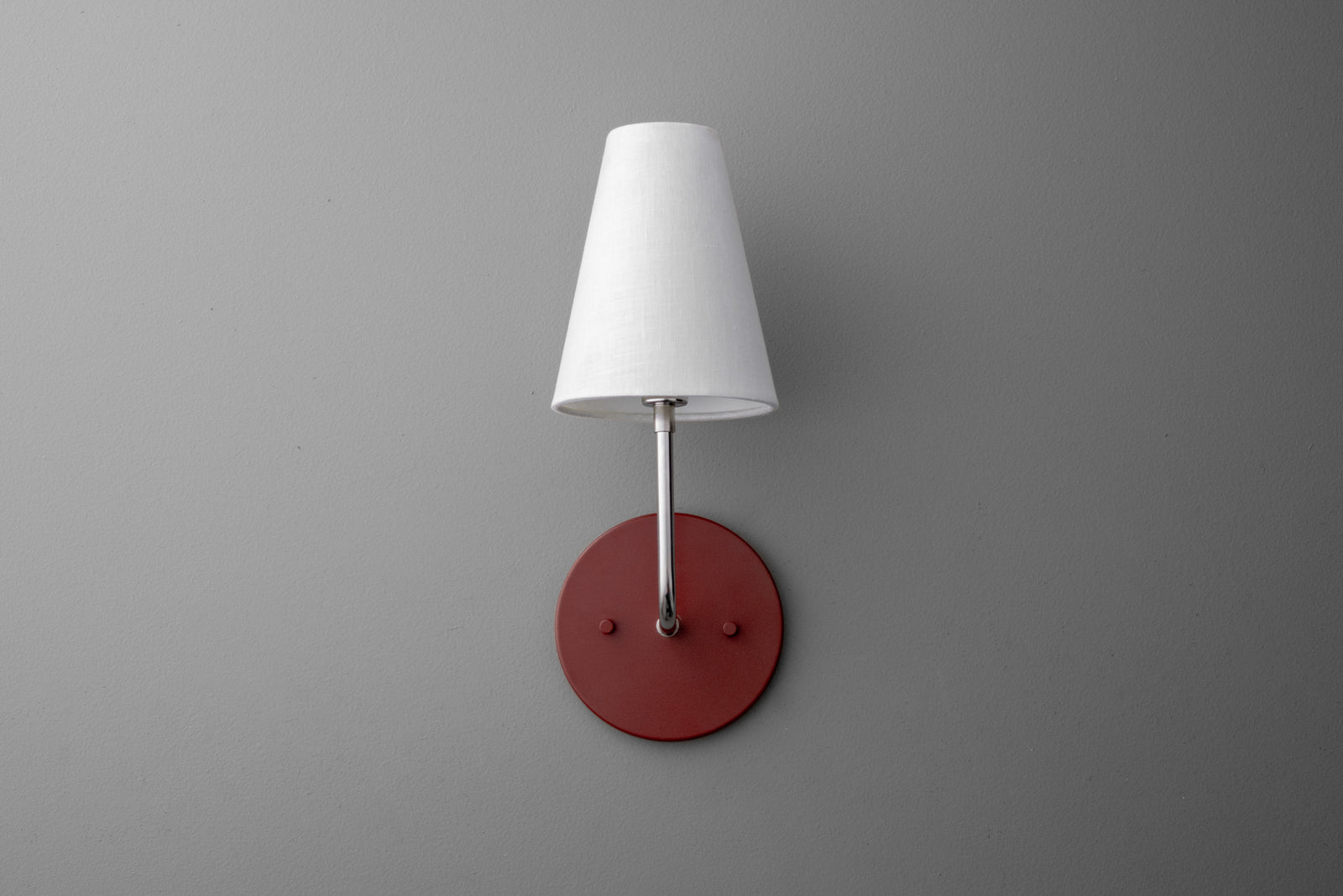 Wall sconce with polished nickel arm, white tapered fabric shade, and brick red round metal base. - SCONCE MODEL NO. 3928
