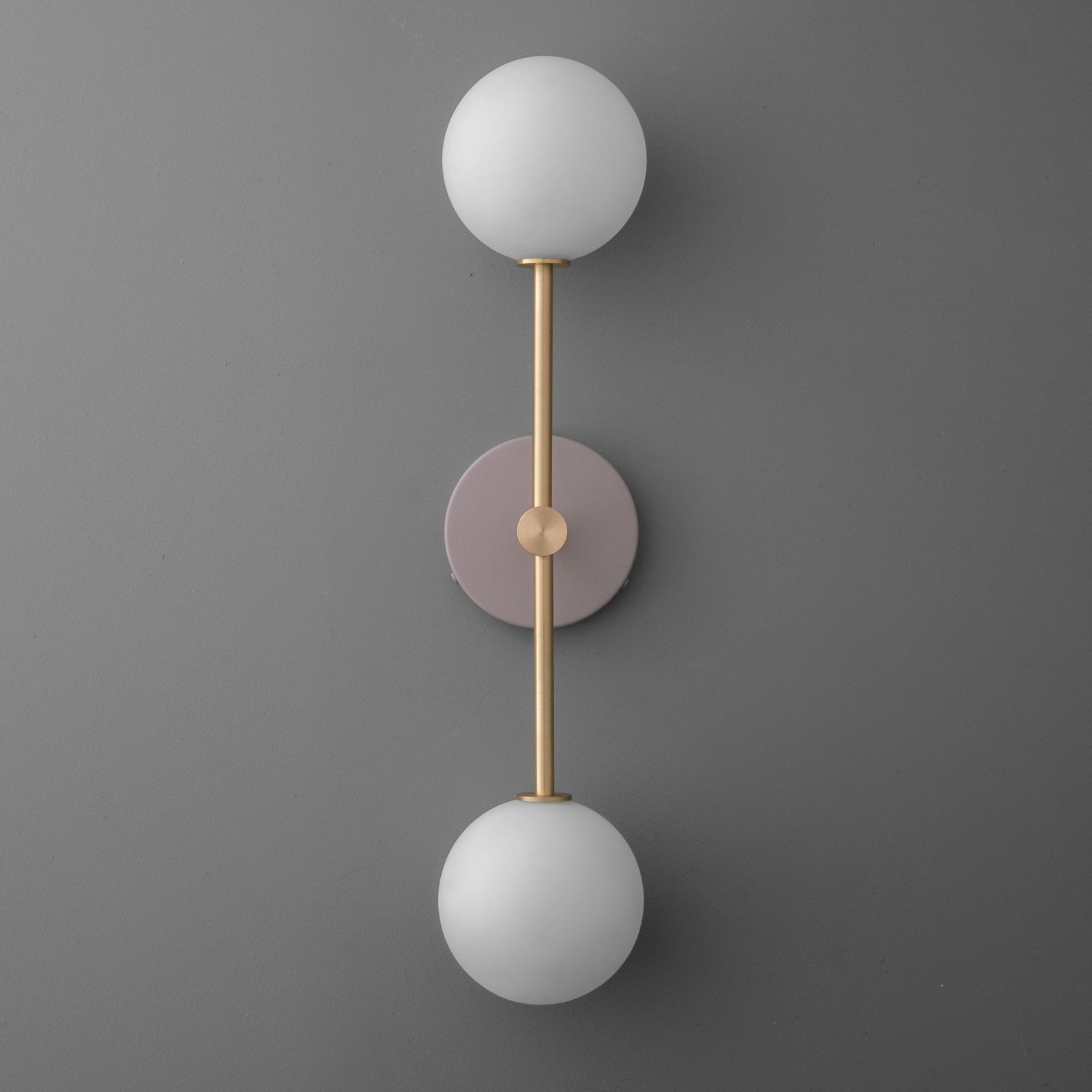 Vertical double globe wall sconce with matte mauve round backplate and raw brass rod. - SCONCE MODEL NO. 9776