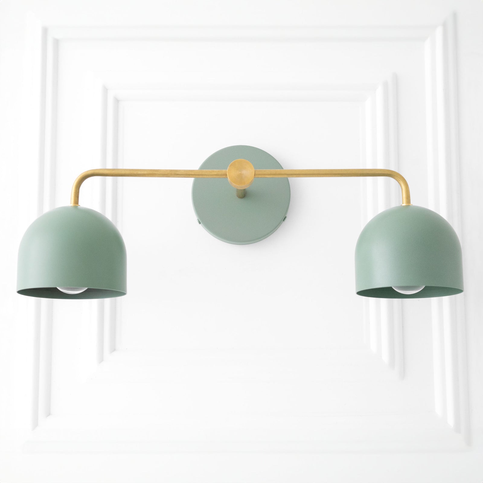 Mid-century modern vanity light with two matte sage green dome shades and a brass horizontal arm. - VANITY LIGHT MODEL NO. 2082