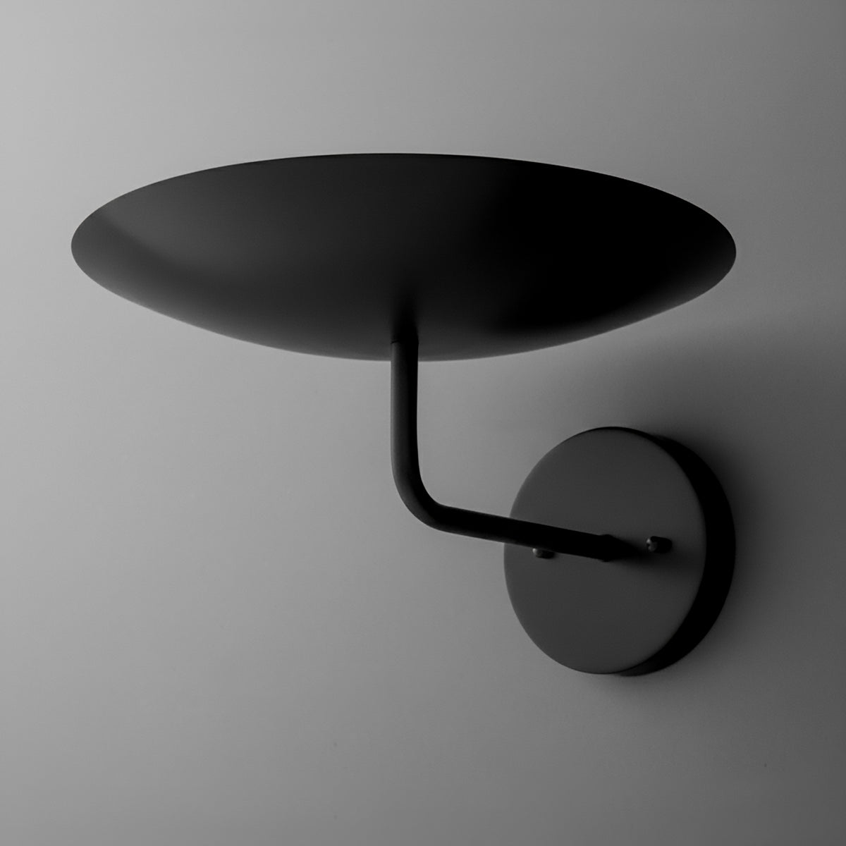 Matte black metal wall sconce with a round base and wide, shallow dome-shaped shade. - SCONCE MODEL NO. 1504