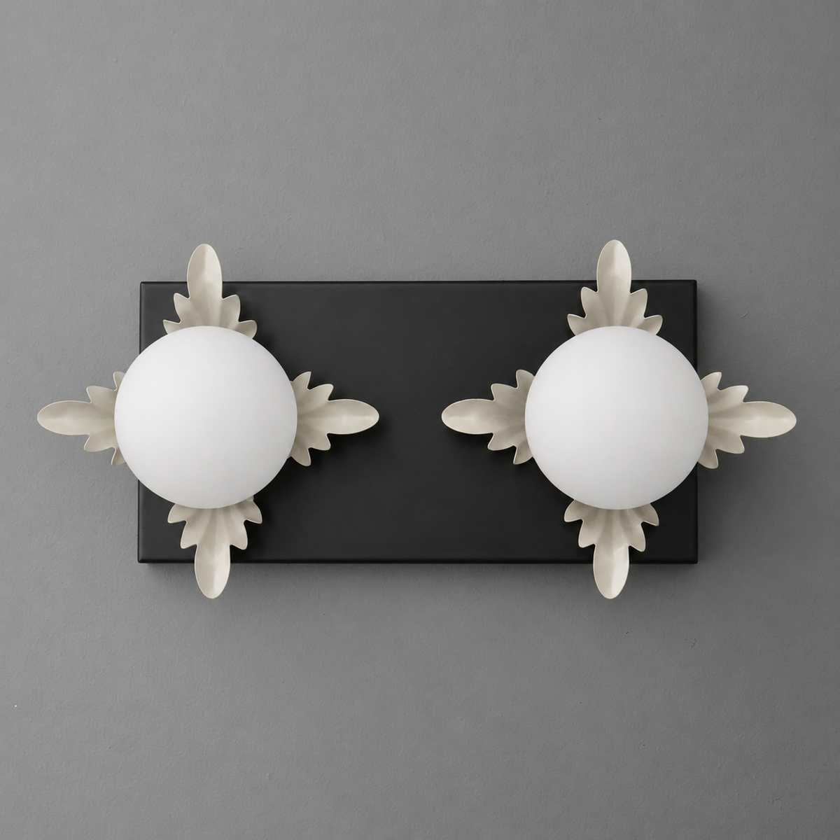 Two-bulb black rectangular sconce with frosted white glass globes and decorative white leaf accents. - SCONCE MODEL NO. 1114