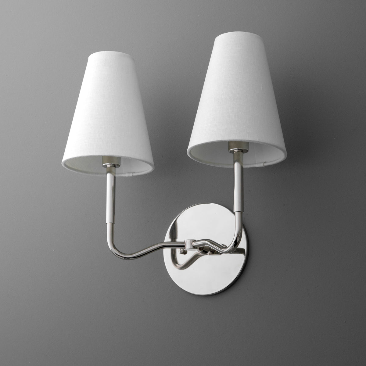 Two-bulb wall sconce with white tapered fabric shades and polished chrome curved arms on round backplate. - SCONCE MODEL NO. 9045