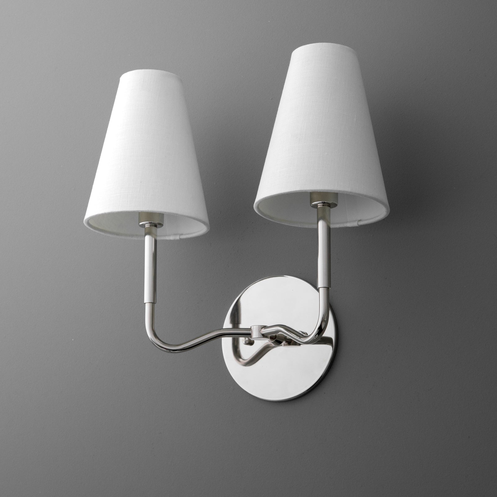 Two-bulb wall sconce with white tapered fabric shades and polished chrome curved arms on round backplate. - SCONCE MODEL NO. 9045