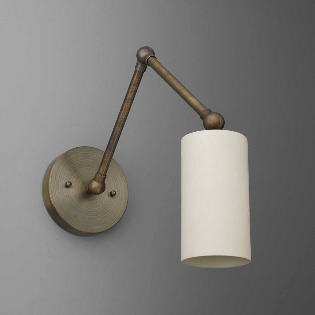 Antique brass wall sconce with adjustable arm and cylindrical white fabric shade. - SCONCE MODEL NO. 0357
