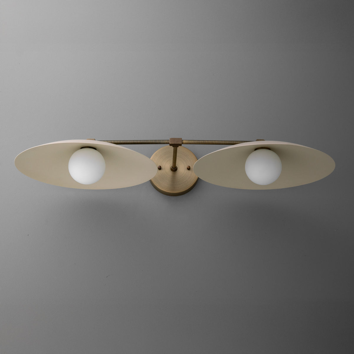 Matte gold two-bulb vanity light with oval metal shades and round frosted glass bulbs. - VANITY LIGHT MODEL NO. 1168