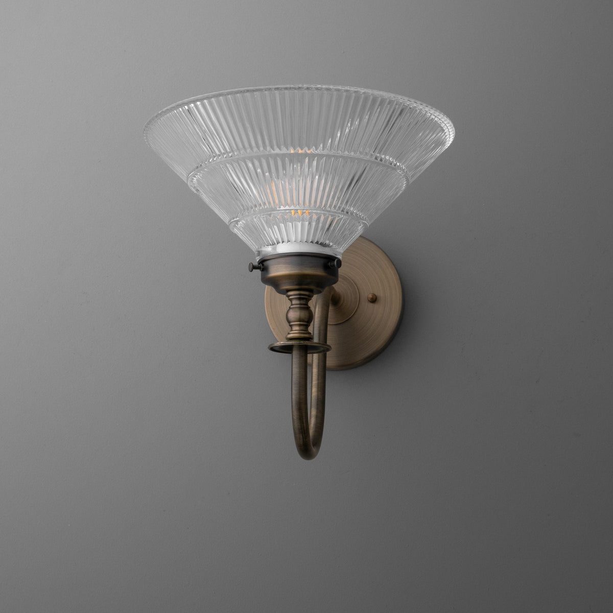Antique brass wall sconce with ribbed clear glass shade in a flared cone shape. - SCONCE MODEL NO. 8036