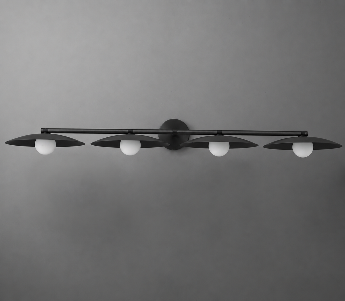Black metal vanity light fixture with four evenly spaced frosted globe bulbs mounted on a horizontal bar. - VANITY LIGHT MODEL NO. 1152