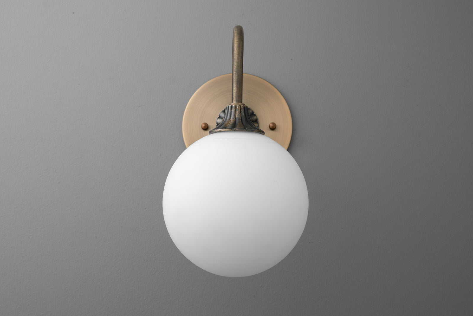 Antique brass wall sconce with round white glass globe light and minimalist design. - SCONCE MODEL NO. 8263