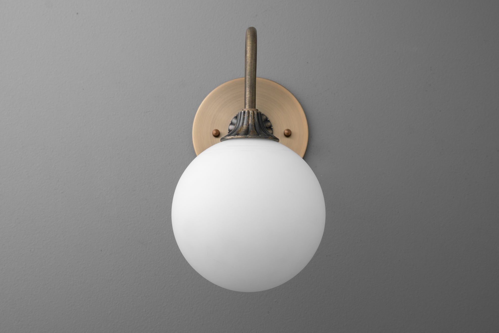 Antique brass wall sconce with round white glass globe light and minimalist design. - SCONCE MODEL NO. 8263