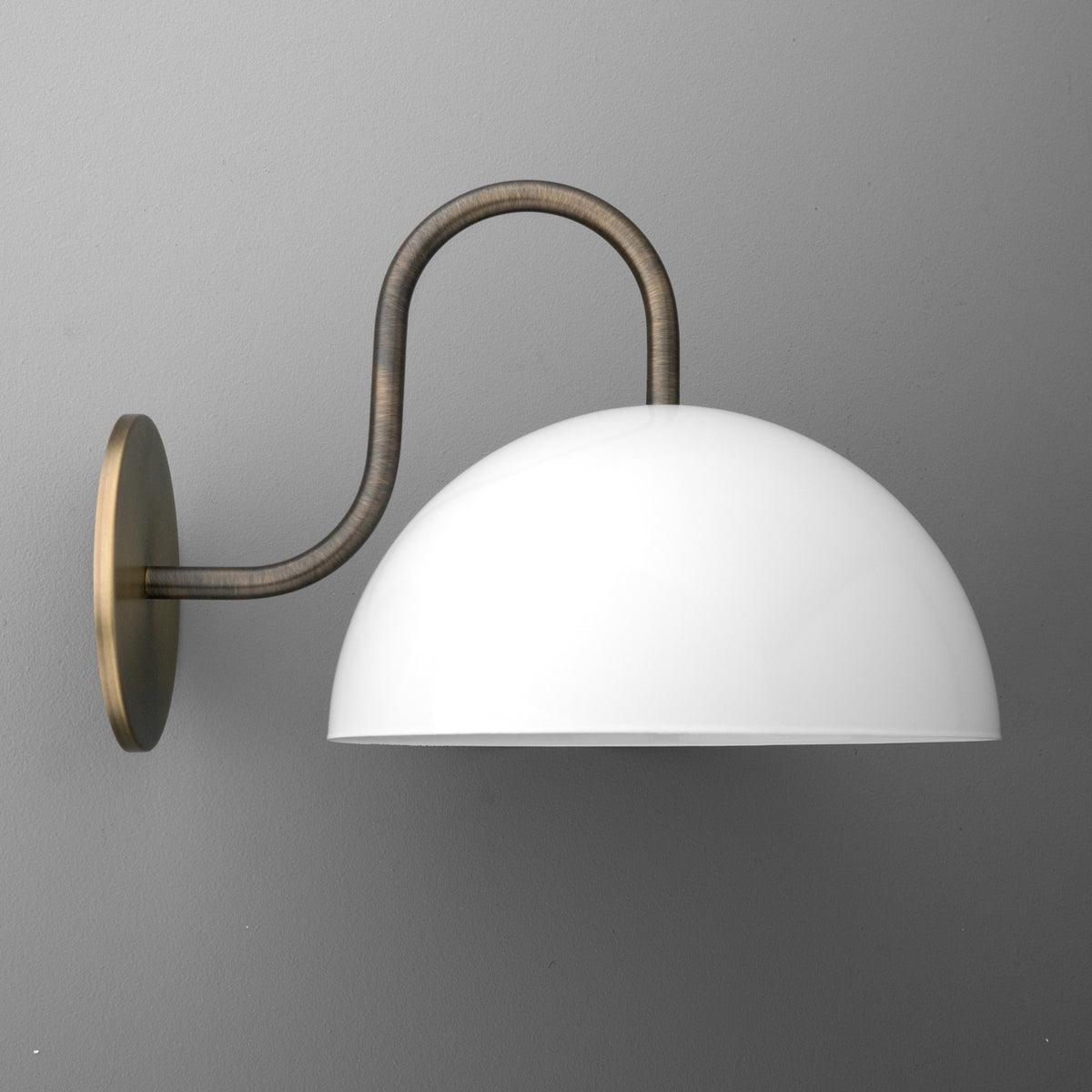 Wall-mounted sconce with curved antique brass arm and large white dome-shaped shade. - SCONCE MODEL NO. 1162