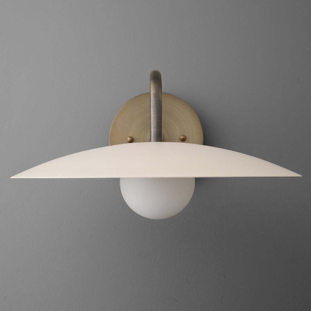 Antique brass wall sconce with cream curved shade and round frosted bulb socket. - SCONCE MODEL NO. 2162
