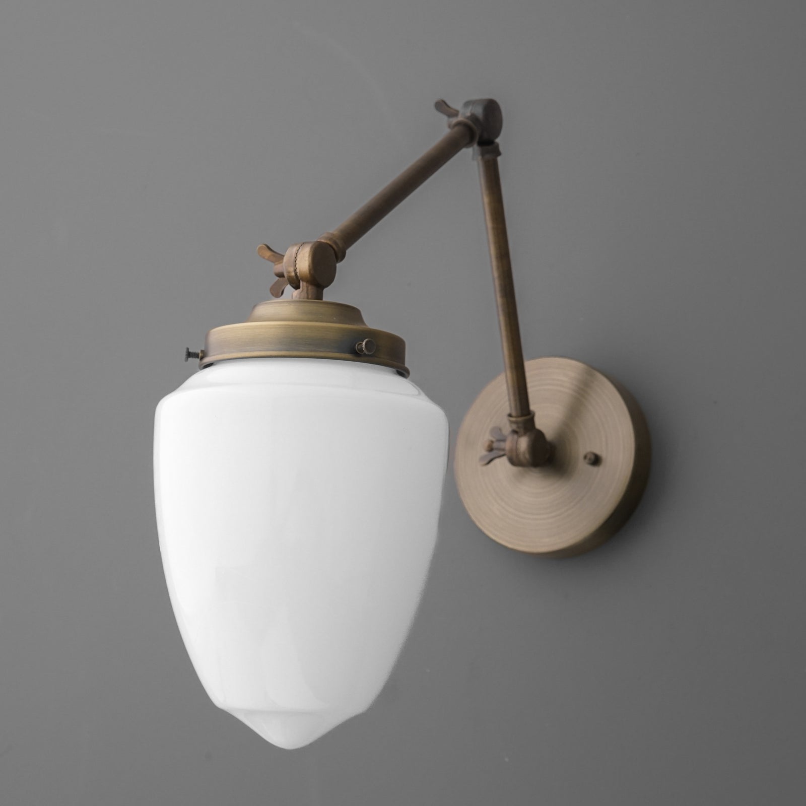 Matte brass wall sconce with adjustable arm and frosted white glass shade, vintage style. - SCONCE MODEL NO. 2595