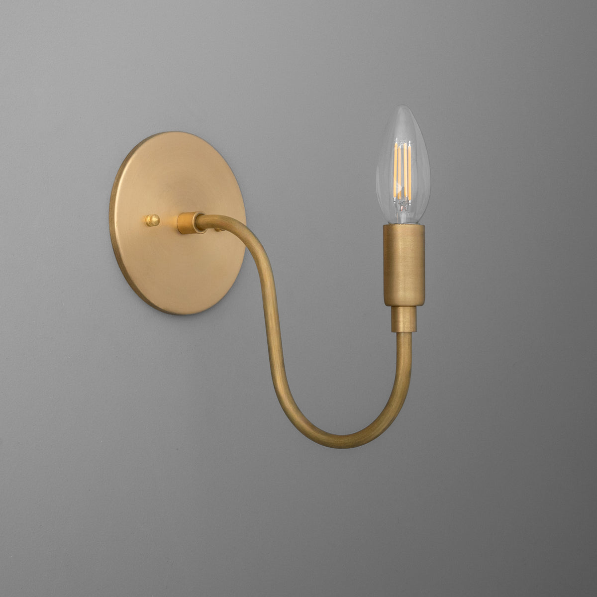 Matte gold metal wall sconce with curved arm and exposed vintage-style bulb. - SCONCE MODEL NO. 7321