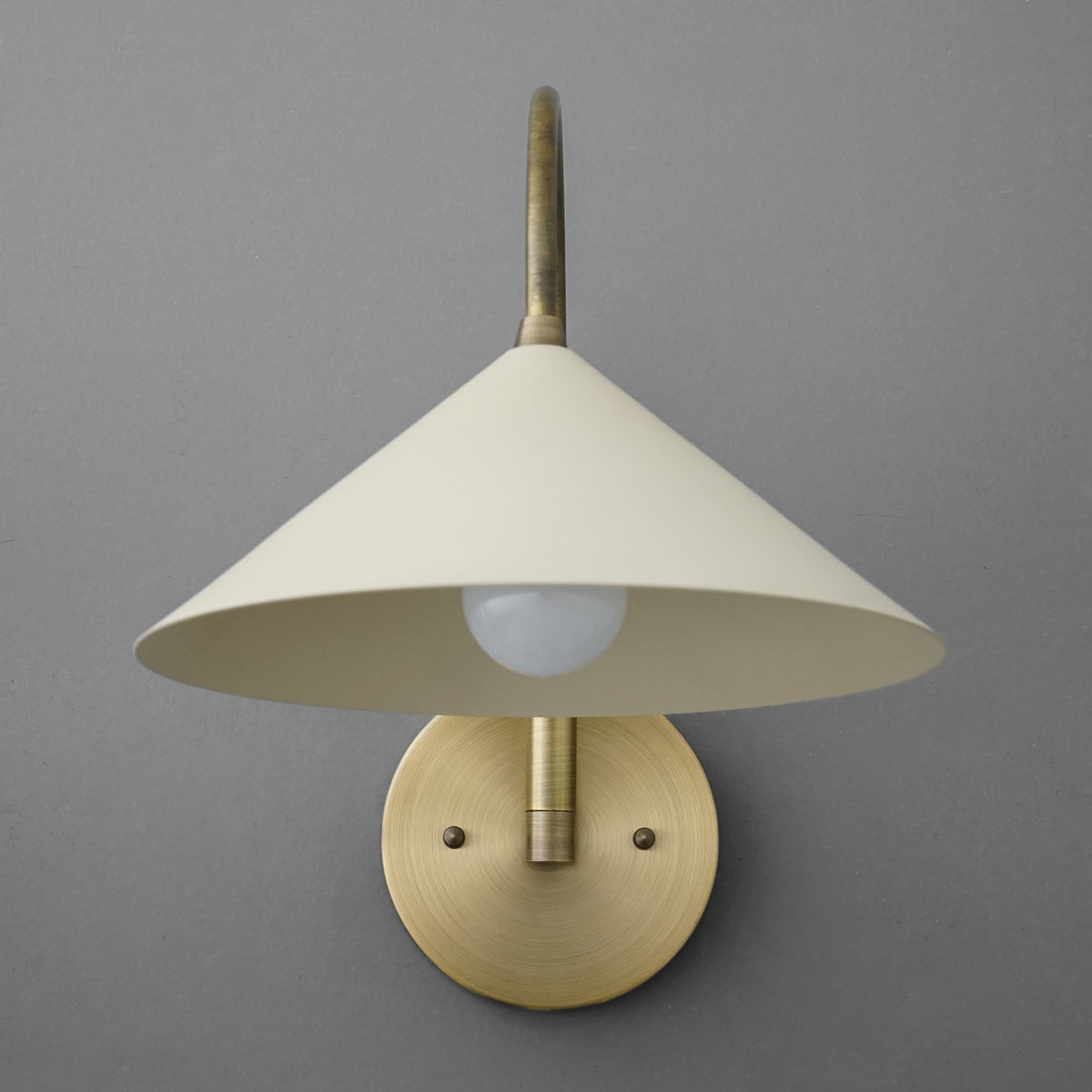 Antique brass wall sconce with cream conical metal shade and round backplate. - Sconce Model No. 1583