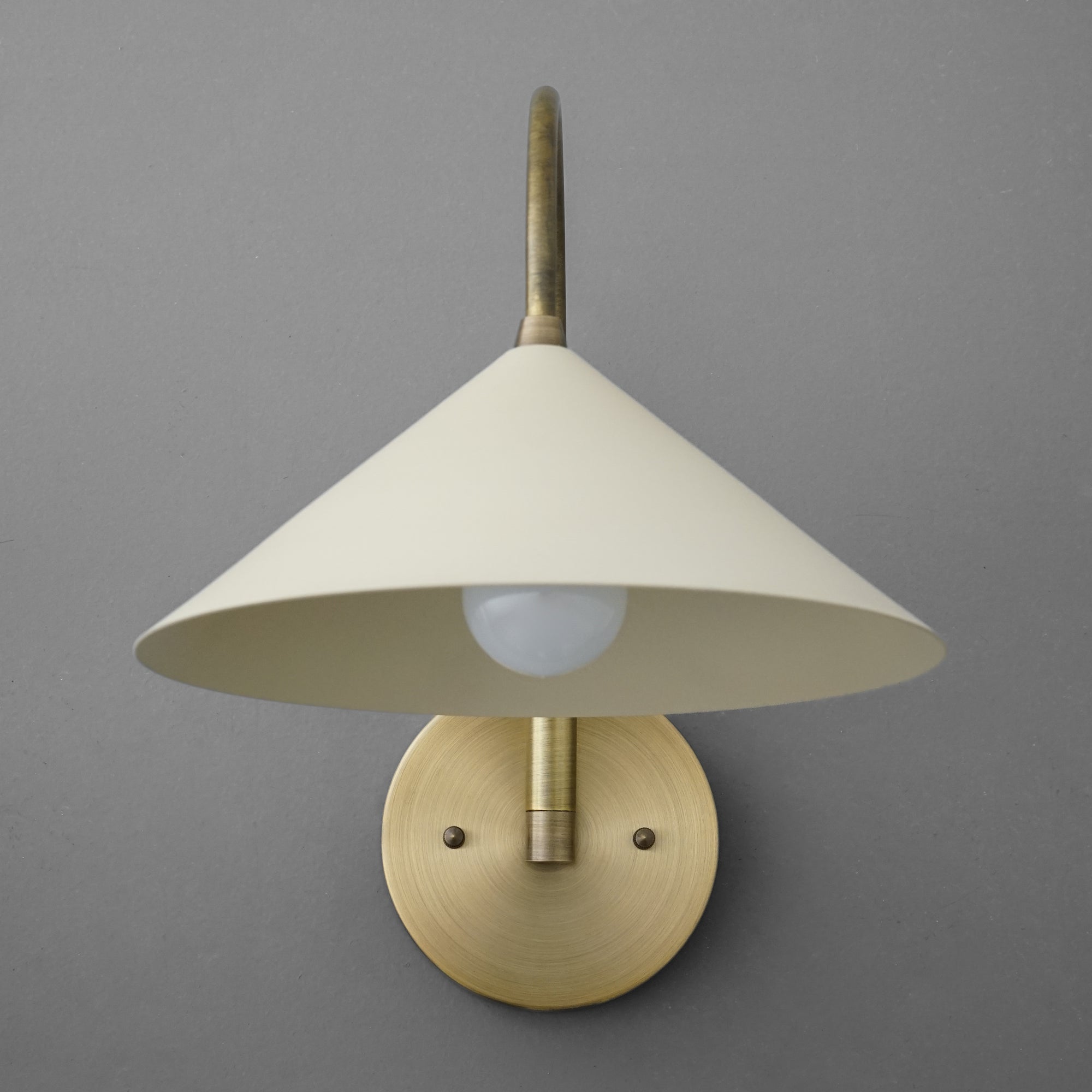 Antique brass wall sconce with cream conical metal shade and round backplate. - Sconce Model No. 1583