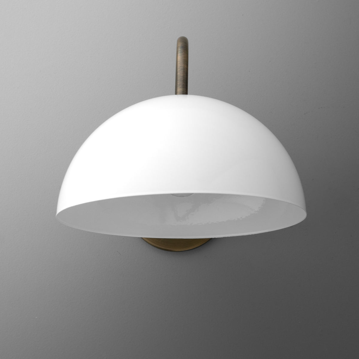 White dome-shaped metal wall sconce with a single bulb and antique brass mounting plate. - SCONCE MODEL NO. 1162