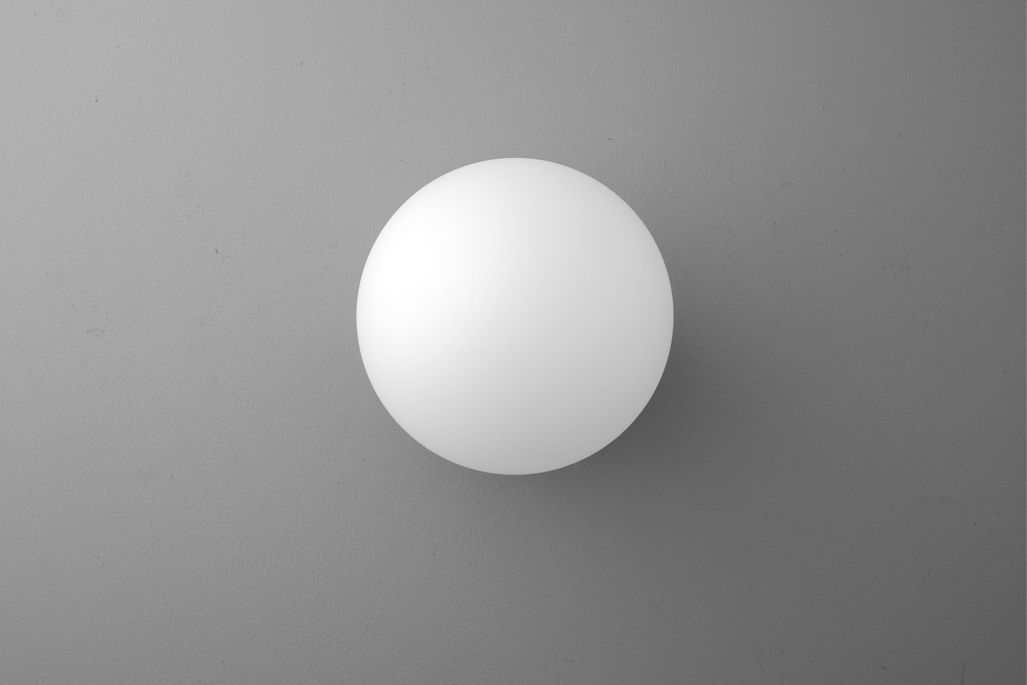 White spherical globe wall sconce with smooth matte finish against gray background. - SCONCE MODEL NO. 4943