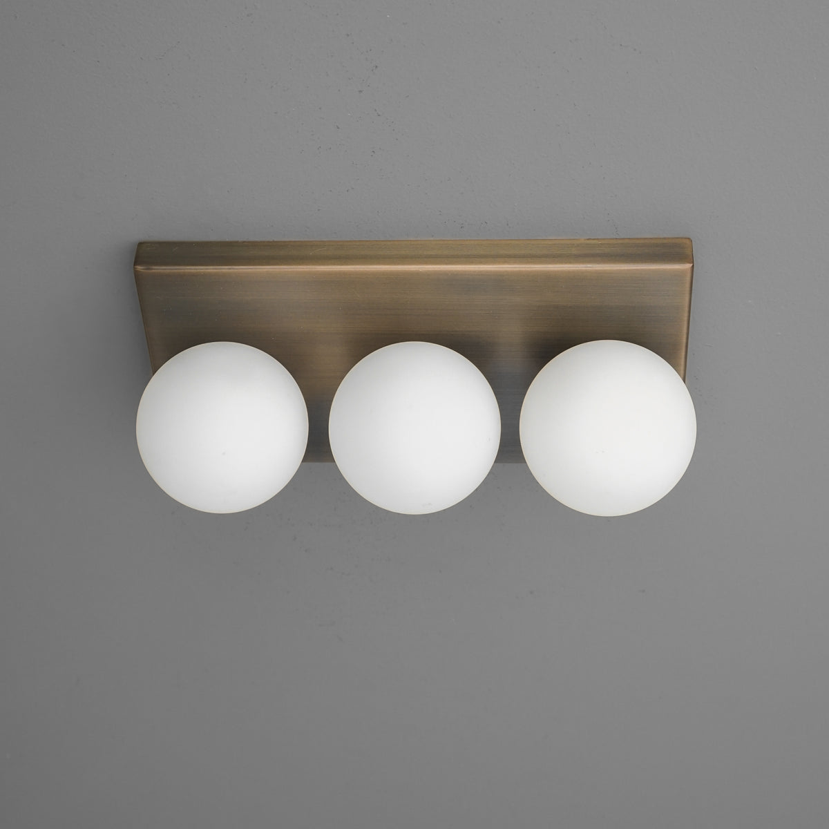 Three-globe wall sconce with frosted white glass shades mounted on brushed bronze rectangular base. - SCONCE MODEL NO. 2623