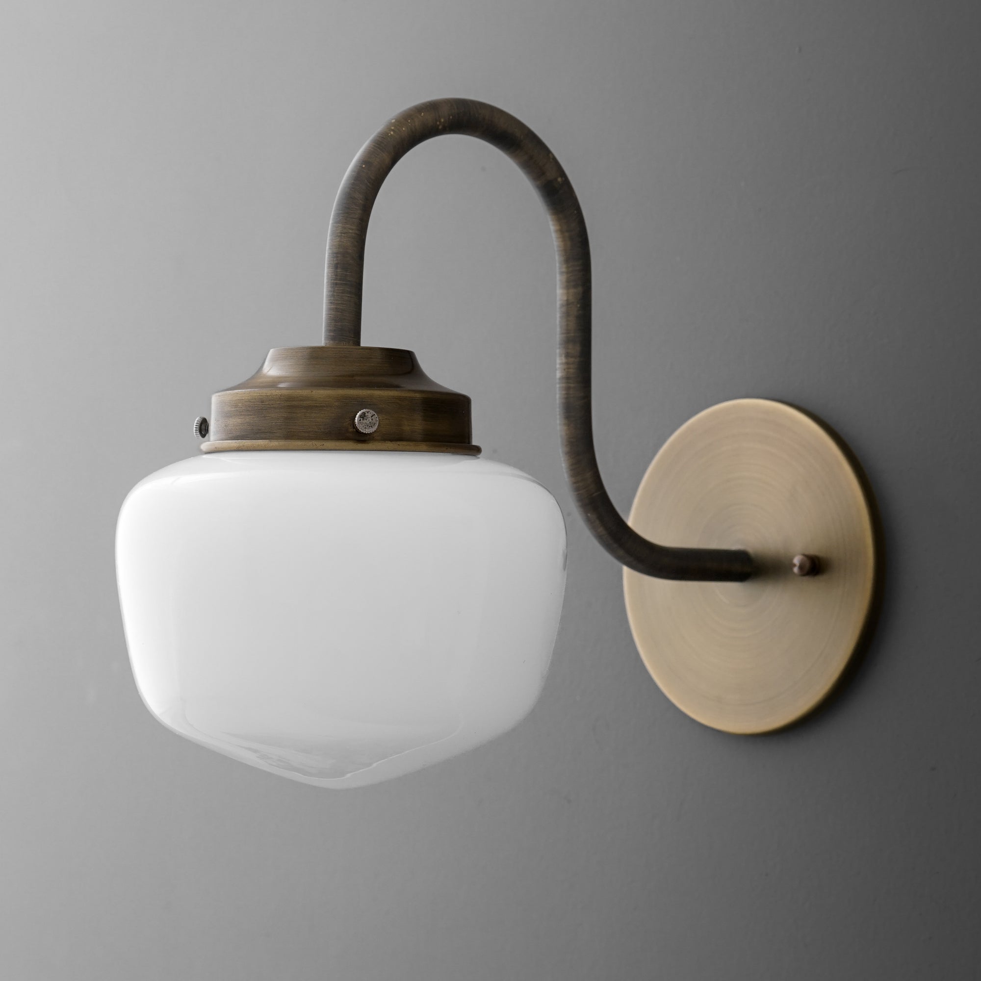 Vintage brass wall sconce with curved arm and frosted white glass shade. - SCONCE MODEL NO. 1012
