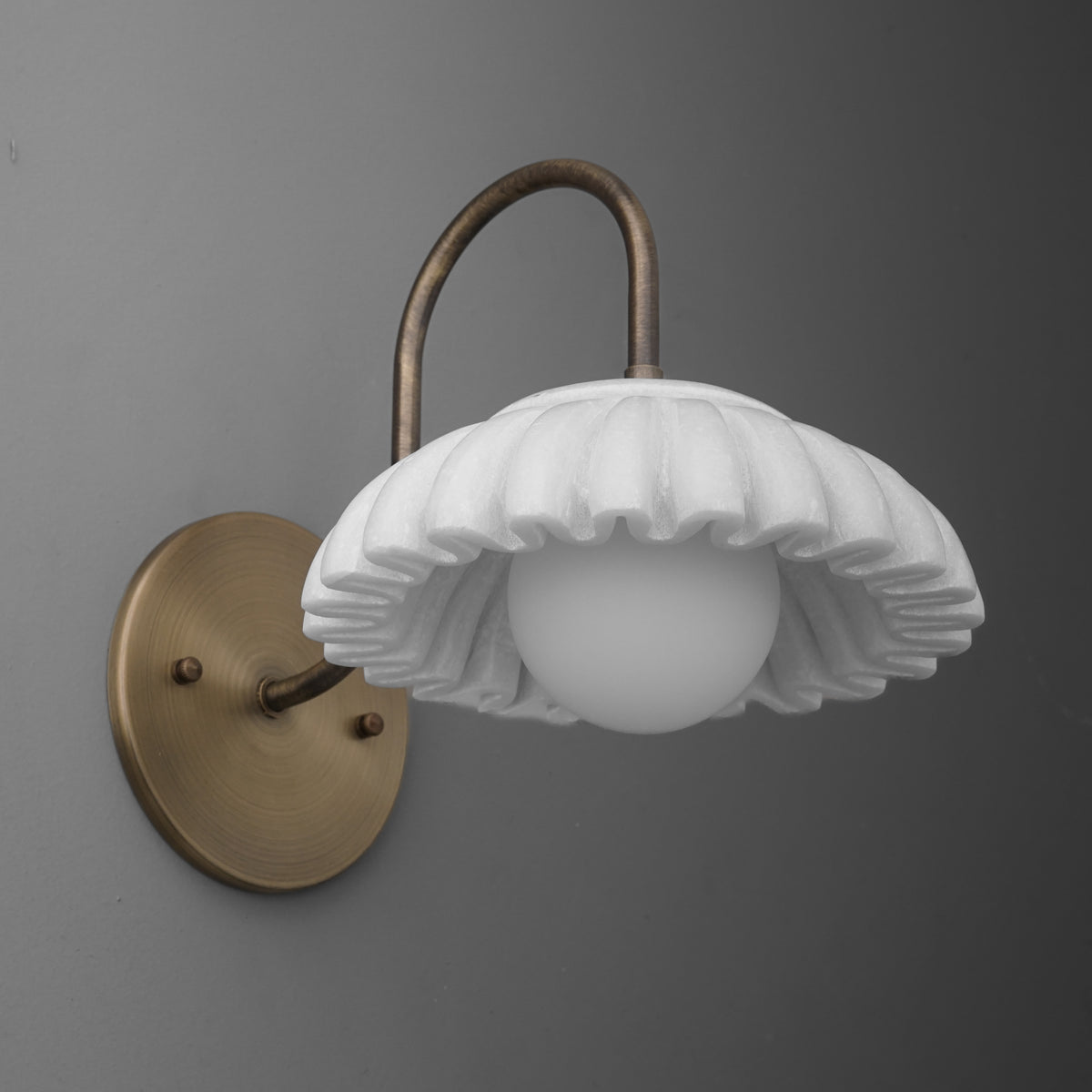 Antique brass wall sconce with curved arm and white fluted glass shade surrounding light bulb. - SCONCE MODEL NO. 2782
