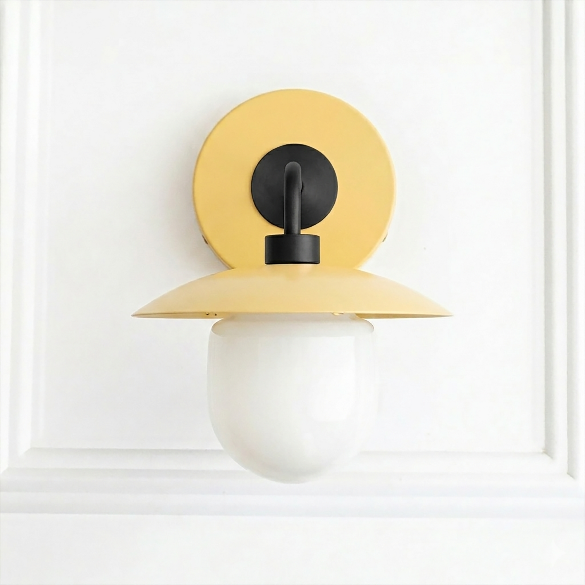 Mid-century modern sconce with matte yellow circular backplate and dome shade, frosted globe bulb. - SCONCE MODEL NO. 7039