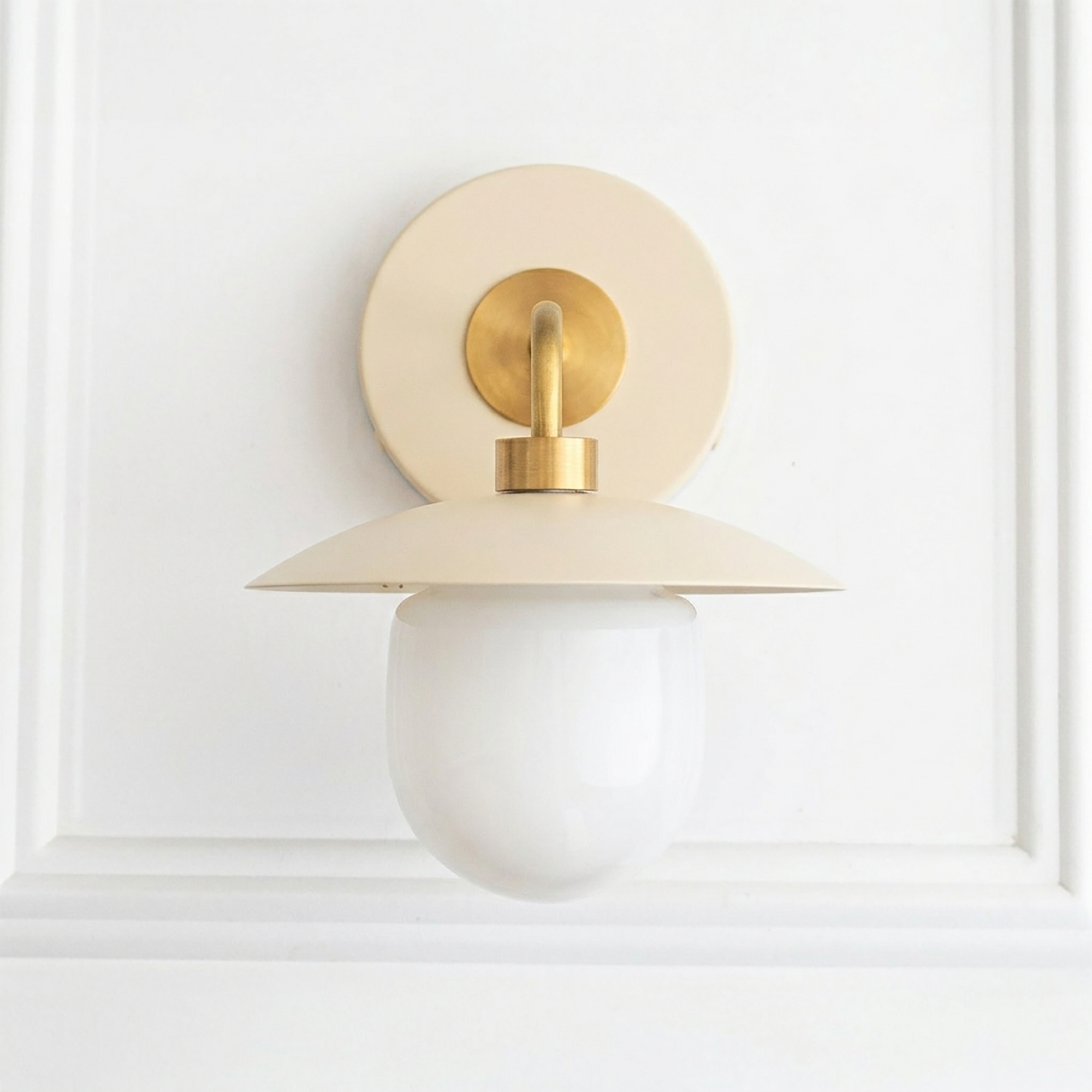 Mid-century modern cream and brass sconce with round backplate and frosted globe bulb shade. - SCONCE MODEL NO. 7039