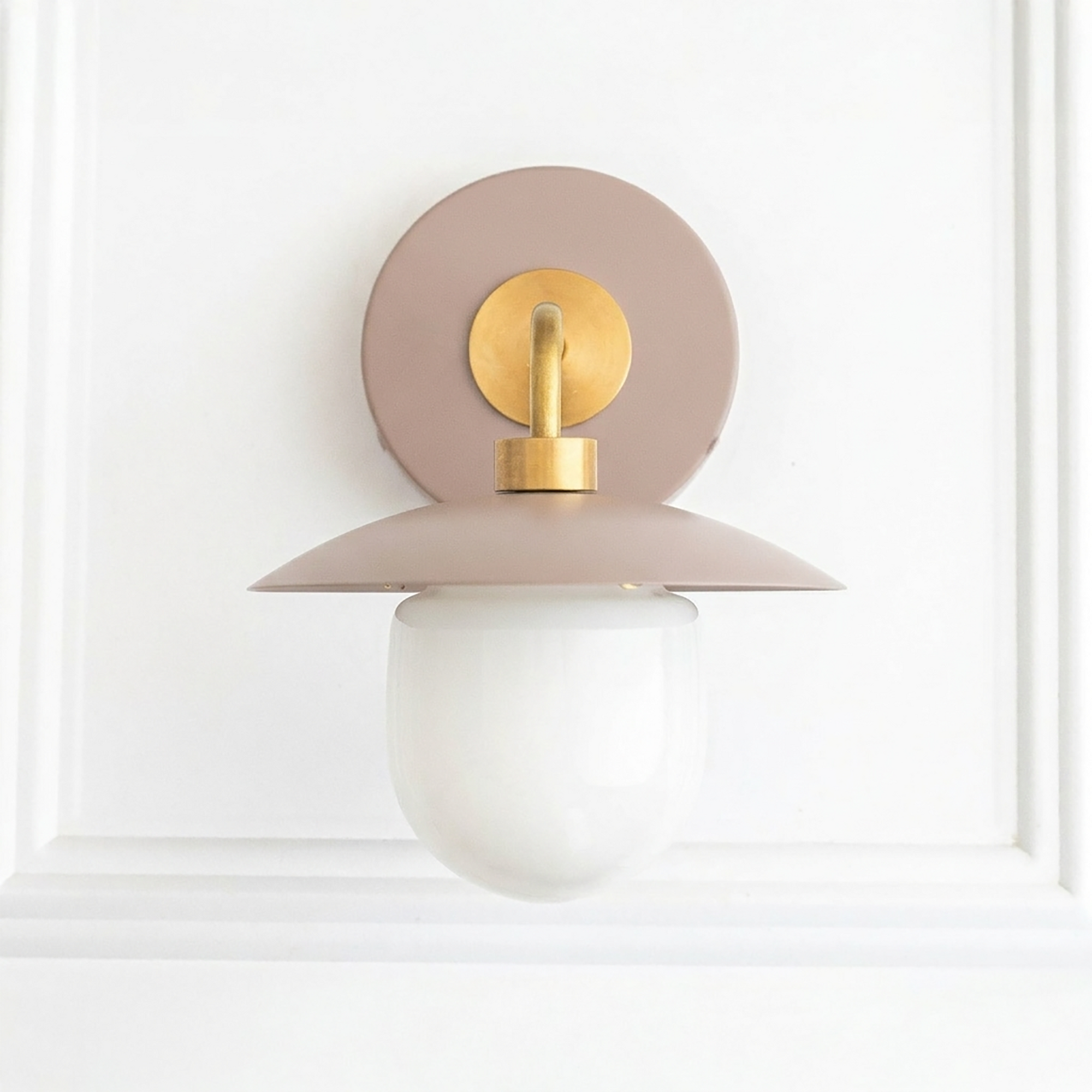 Mid-century modern wall sconce with matte dusty pink metal base, brass accents, and white frosted glass globe shade. - SCONCE MODEL NO. 7039