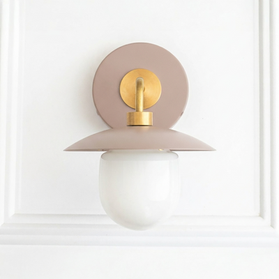 Mid-century modern wall sconce with matte dusty pink metal base, brass accents, and white frosted glass globe shade. - SCONCE MODEL NO. 7039