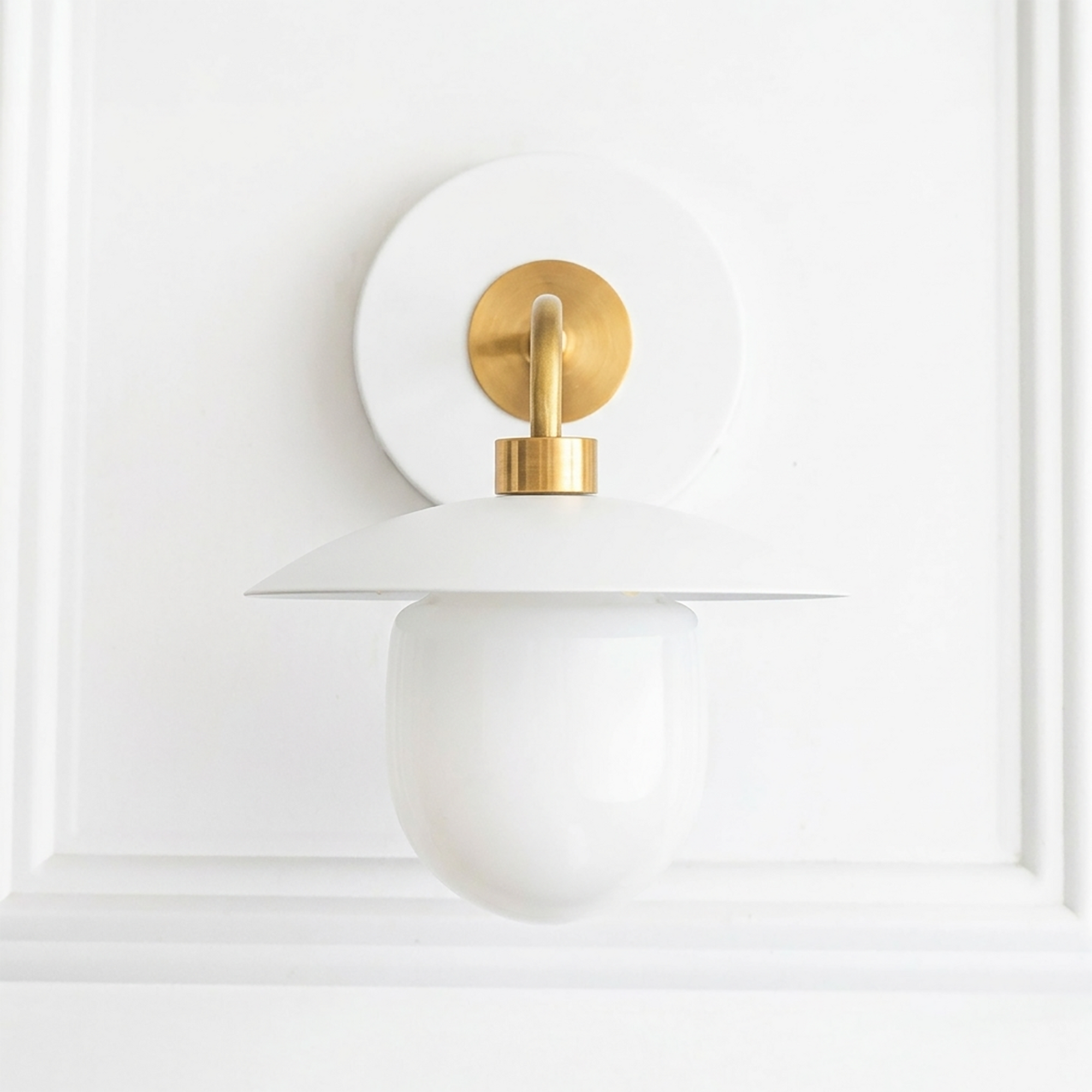White and brass mid-century modern wall sconce with round backplate and globe shade. - SCONCE MODEL NO. 7039