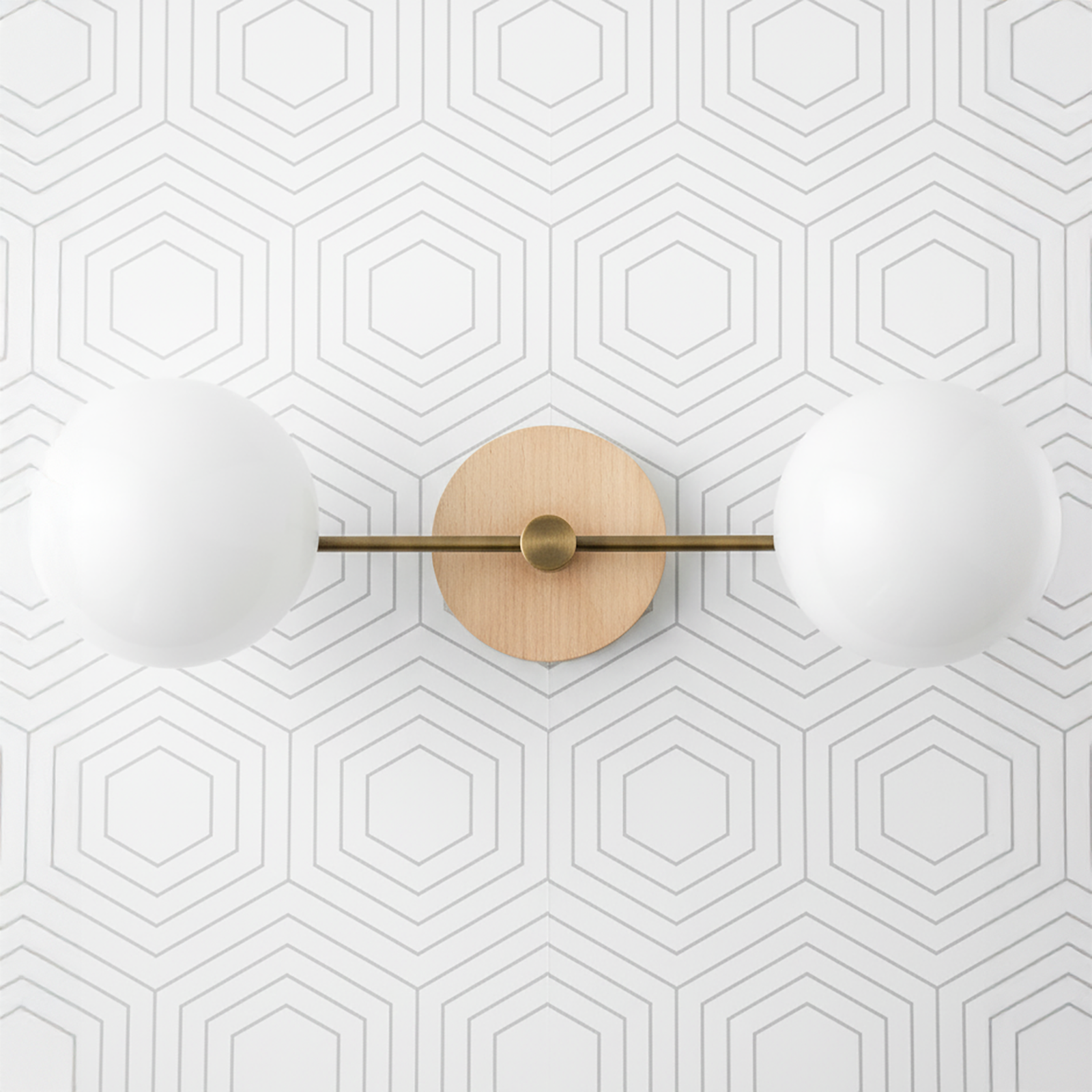 Two-globe vanity light with sealed brass finish and natural wood round backplate on geometric white wall. - VANITY LIGHT MODEL NO. 9474