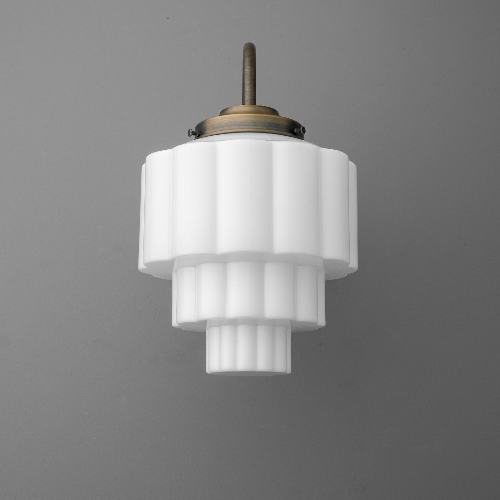 White tiered glass pendant sconce with brass fixture and curved arm mount. - SCONCE MODEL NO. 1095