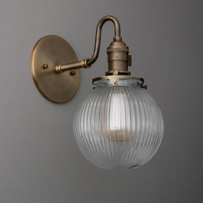 Antique brass wall sconce with ribbed clear glass globe shade and exposed bulb. - SCONCE MODEL NO. 3331