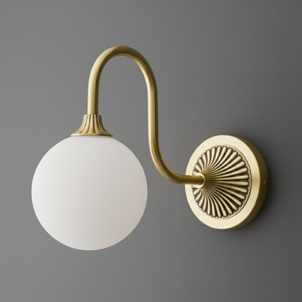 Brushed brass single-bulb wall sconce with curved arm and frosted white glass globe shade. - SCONCE MODEL NO. 1085