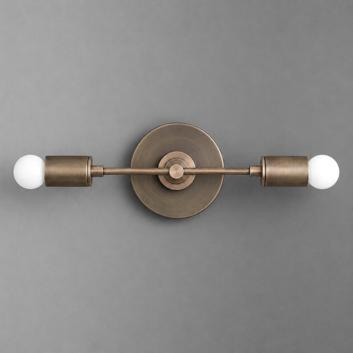 Two-bulb vanity light with matte bronze finish and round backplate on gray background. - VANITY LIGHT MODEL NO. 8057