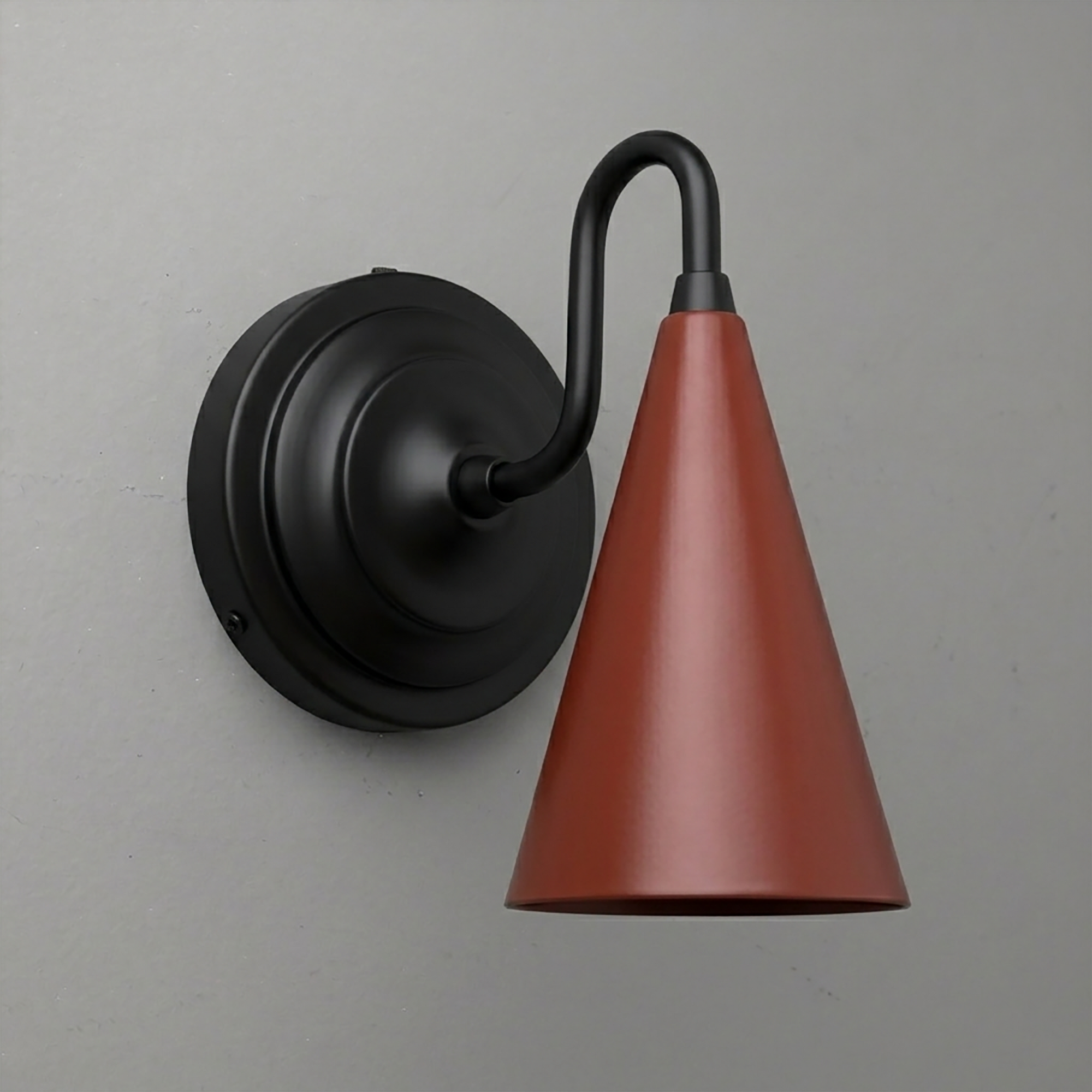 Matte black metal sconce with a curved arm and rust-colored tapered cone shade pointing downward. - Sconce Model No. 6790