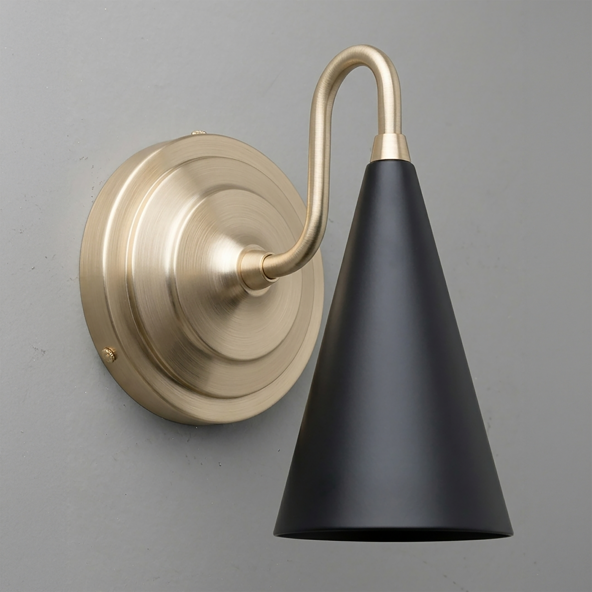 Matte black metal cone-shaped shade sconce with brushed brass curved arm and round wall mount. - Sconce Model No. 6790
