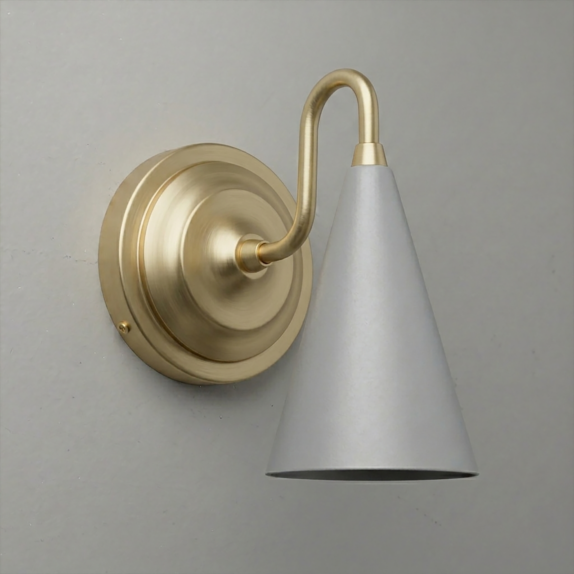 Brushed brass wall sconce with a conical white metal shade and curved arm mounting on round backplate. - Sconce Model No. 6790