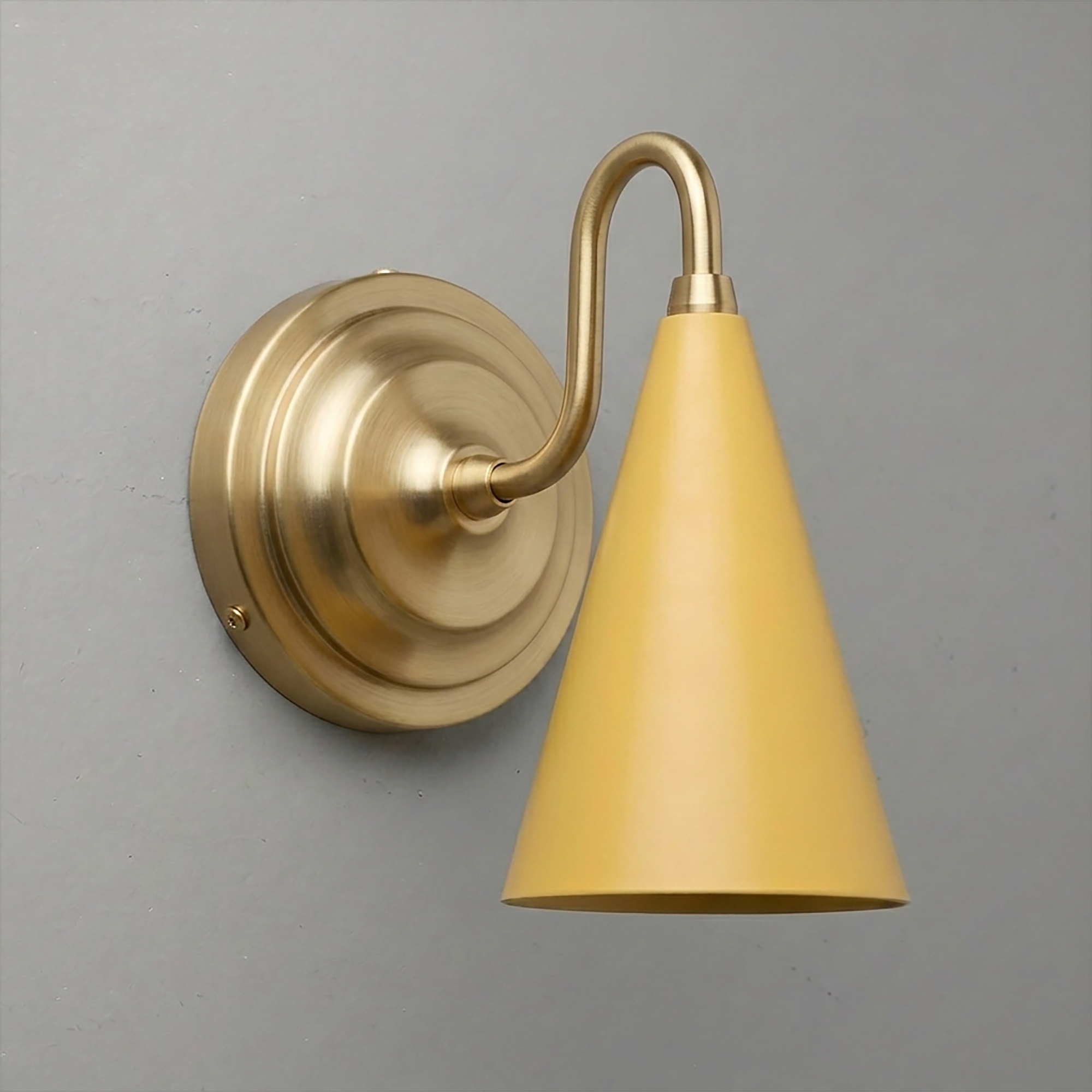 Brushed brass wall sconce with a curved arm and matte yellow conical metal shade pointing downward. - Sconce Model No. 6790