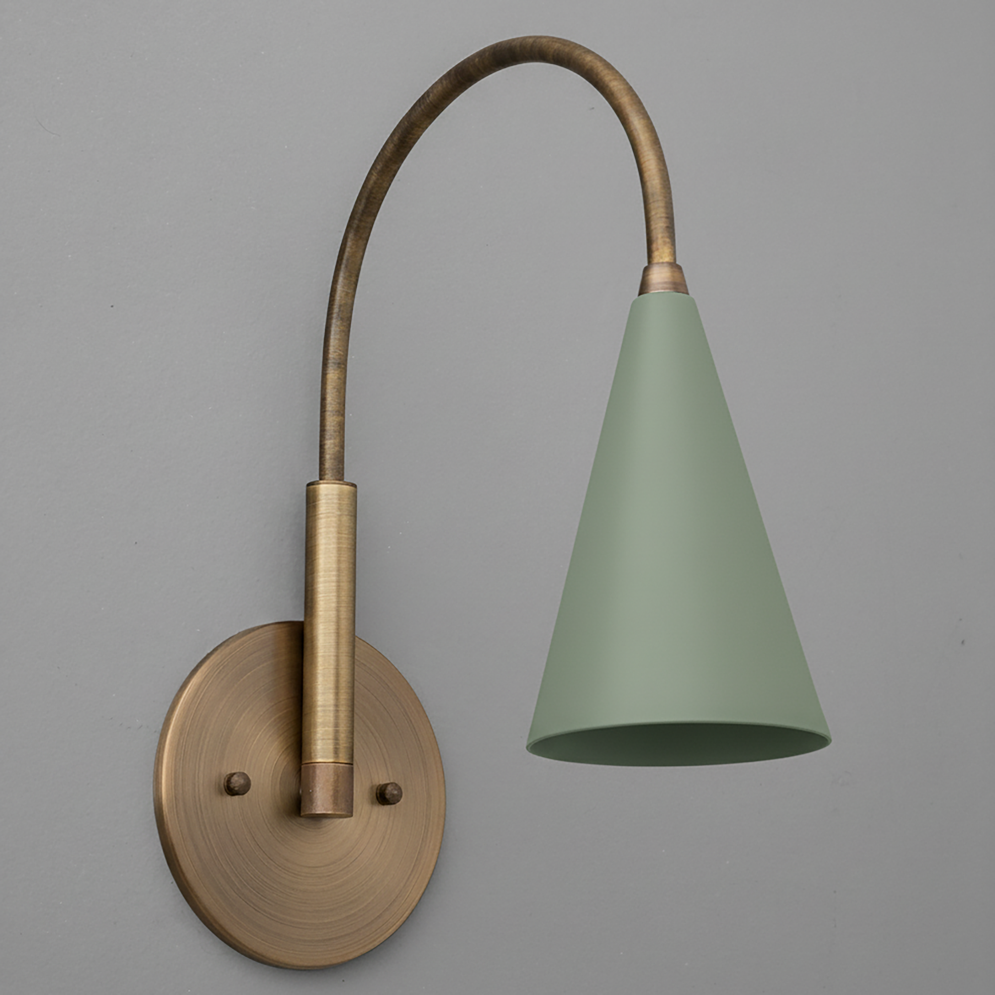 Wall-mounted sconce with brushed brass finish and curved arm holding a matte sage green conical shade. - SCONCE MODEL NO. 1309