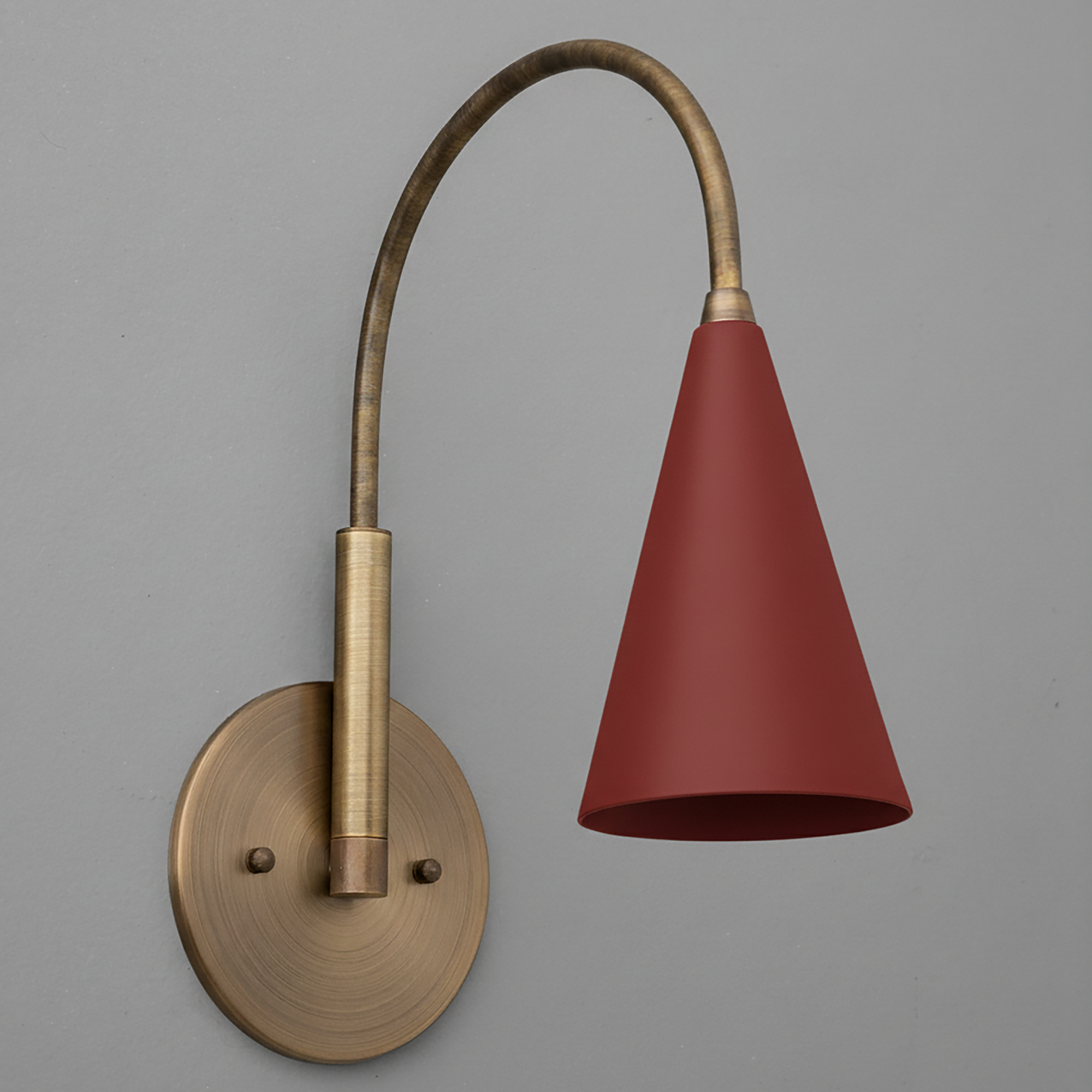 Wall-mounted brass sconce with curved arm and matte red conical metal shade. - SCONCE MODEL NO. 1309