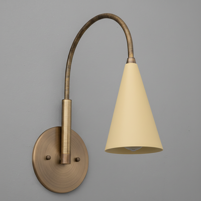 Wall sconce with curved antique brass arm and matte beige conical metal shade. - SCONCE MODEL NO. 1309